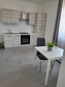 uma cozinha com uma mesa branca e um fogão branco em Nautica Tarello - Casa Ena BeB em Viverone