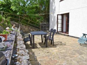 a table and chairs sitting on a stone patio at Rallt Fawr in Gwalchmai