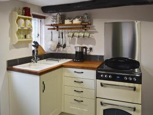 a kitchen with a sink and a stove at Farm Cottage in Margate