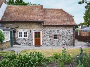 a stone house with a red door and a yard at Farm Cottage in Margate