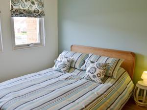 ビードネルにあるThe Havenのベッドルームに枕付きのベッド、窓が備わります。