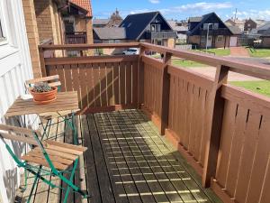 a wooden deck with a table and a chair on a balcony at The Haven in Beadnell