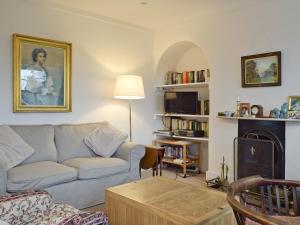 a living room with a couch and a fireplace at Jubilee Cottage in Enstone