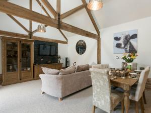 a living room with a couch and a table at The Cow Shed in Horning