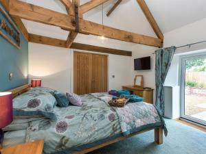 a bedroom with a large bed and a window at The Cow Shed in Horning