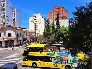 un autobús amarillo conduciendo por una calle de la ciudad con edificios en Casco Histórico en Buenos Aires