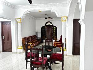 una sala da pranzo con tavolo e sedie di Kovalam Beach House a Trivandrum