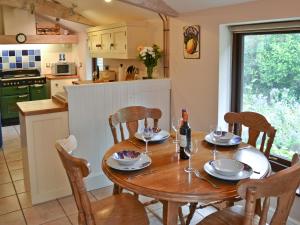 une salle à manger avec une table en bois et des verres à vin dans l'établissement Saracens Retreat, à Thurgarton