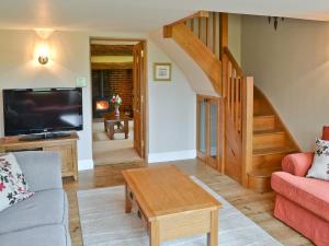 a living room with a couch and a tv at Saracens Retreat in Thurgarton