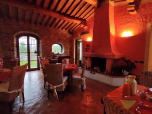 a restaurant with tables and chairs and a fireplace at Bio Agriturismo La Bell'Antiglia in Montemerano