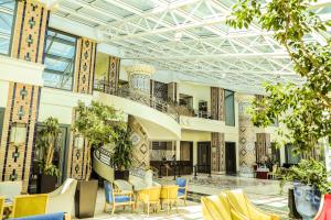 a lobby with chairs and tables in a building at City Palace Hotel Tashkent in Tashkent