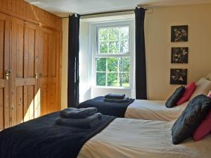 een slaapkamer met 2 bedden en een raam bij Foldgate in Waberthwaite