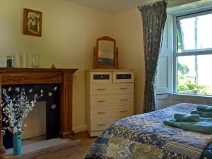 een slaapkamer met een bed, een spiegel en een open haard bij Foldgate in Waberthwaite