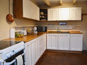 a kitchen with white cabinets and a counter top at Halfway House in Brixham