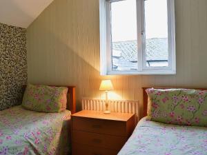a small bedroom with two beds and a window at Halfway House in Brixham