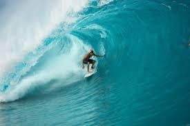 un hombre montando una ola en una tabla de surf en el océano en Résidence Fanti, en Sidi Binnzarene