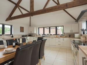 a large kitchen with a wooden table and chairs at Summer House Stables in Catfield