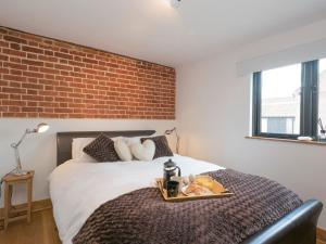 a bedroom with a bed with a tray of food on it at Summer House Stables in Catfield