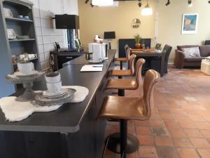 kuchnia z blatem ze skórzanymi stołkami barowymi w obiekcie familiehuis Amber w mieście Haaksbergen