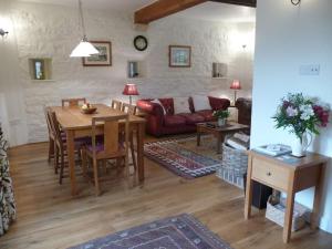 a living room with a table and a couch at Brook Cottage in Baltonsborough