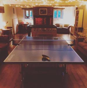 a ping pong table in the middle of a living room at Brook Cottage in Baltonsborough