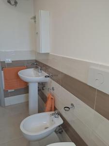 a bathroom with a white sink and a toilet at Casa Istadi in Maracalagonis