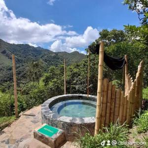 una bañera de hidromasaje en medio de una montaña en Colibamboo The Cabin. Cabaña elevada con mirador montaña malla y jacuzzi, en Pacho