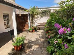 un jardin avec des plantes en pot et des fleurs sur une terrasse dans l'établissement Priory Cottage, à Totnes