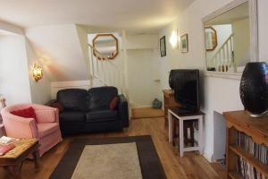 a living room with a couch and a tv at Priory Cottage in Totnes