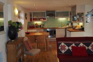 a kitchen with a couch and a table in a room at Priory Cottage in Totnes
