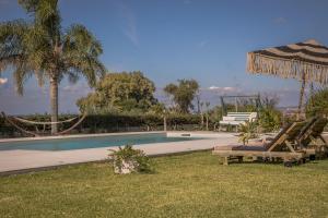 einen Pool mit Liegestühlen und einem Sonnenschirm in der Unterkunft Queen Bee Residence in Minia