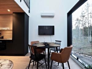 a dining room with a table and chairs and a tv at Levillas Levin Tuulahdus in Sirkka