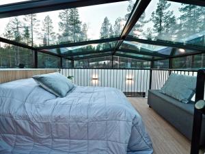 a bedroom with a bed and a couch on a balcony at Levillas Levin Tuulahdus in Sirkka