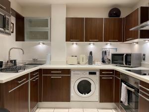 een keuken met een wasmachine en een magnetron bij Stunning Westminster Apartment in Londen