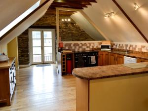 a large kitchen with a counter top in a attic at White Dove Barn in Wembury