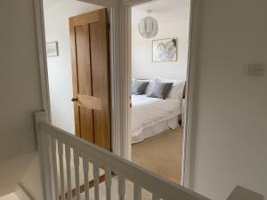 a view of a bedroom with a bed and a mirror at Bayeux Cottage in East Budleigh