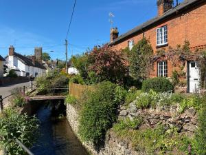 a bridge over a river next to a building at Bayeux Cottage in East Budleigh