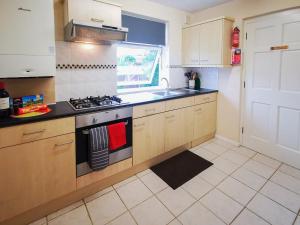 a kitchen with a stove and a sink at Oak Lodge in Longham