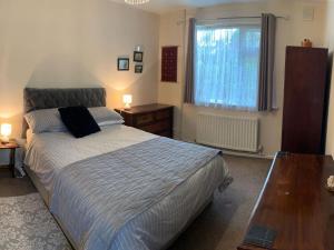 a bedroom with a bed and a table and a window at Oak Lodge in Longham