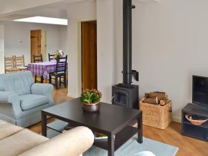 a living room with a wood stove and a table at Haulfryn Cottage in Menai Bridge