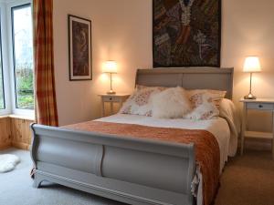 a bed in a bedroom with two lamps and a bed sidx sidx sidx at Haulfryn Cottage in Menai Bridge