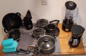 a bunch of pots and pans on a table with a blender at Solarium Flats Itagua - Ubatuba SP in Ubatuba