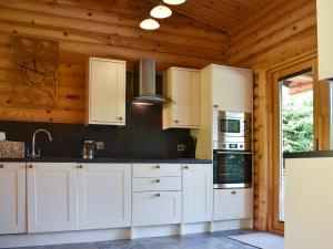 a kitchen with white cabinets and a wooden ceiling at Mayfields Retreat in Newsham