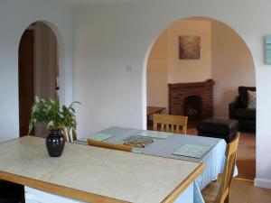 a kitchen with a table and a living room at Castle House Cottage in Horton
