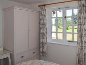 een slaapkamer met een bed en een raam bij Castle House Cottage in Horton
