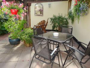 een tafel en stoelen op een patio met bloemen bij Brook Lodge Country Cottage in Wroot