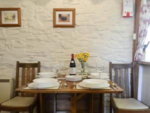 a wooden table with plates and a bottle of wine at The Coach House in Kington