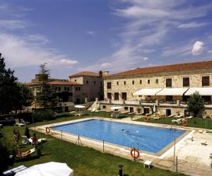 a large swimming pool in front of a building at Parador de Zamora in Zamora