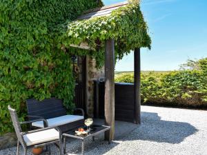 a chair and a table with a glass of wine at Babes Cottage - 27592 in Perranzabuloe