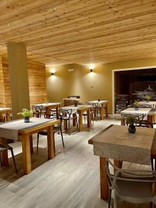 a room with tables and chairs and wooden ceilings at Agriturismo Terre di Ginepro in Borghetto di Vara